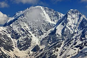 Mount Donguzorun (4, 448m) with Yellow-billed / Alpine chough (Pyrrhocorax graculus) flying