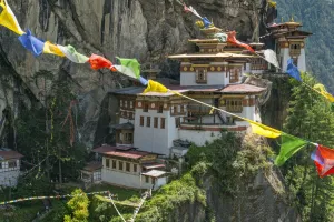 Paro Taktsang / Tigers Nest Buddhist monastery perched on cliffs with prayer flags