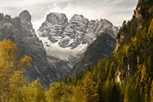 The Three Peaks and Monte Cristallo with autumn trees. Dolomites, Italy, October 2019