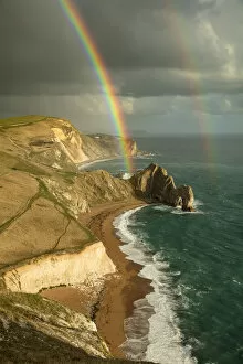 Spectrum Collection: Rainbow over Durdle Door and the Jurassic Coast, Dorset, England, UK. October 2019