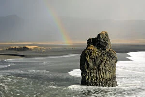 Reynisdrangar basalt sea stack with rainbow, Vik, Iceland, February 2017