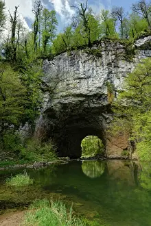 Karst Prints: River under natural stone arch in karst landscape