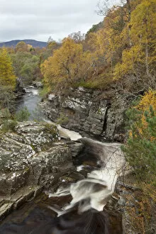River Tromie flowing through gorge in autumn woodland. Cairngorms National Park, Scotland