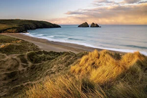 Sand dunes and warm early morning light at Holywell Bay