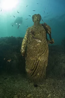 Scuba diver near ancient Roman Statue of Antonia minor, member of Julio-Claudian dynasty
