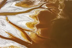 Soda deposits stained by microorganisms and red algae, freshwater inlet in river delta, Lake Magadi, Rify Valley, Kenya. February, 2024