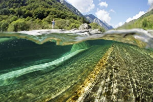 Split level view of blue green waters of Verzasca River flowing over granite rocks at Lavertezzo