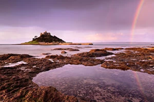 St Michaels Mount at sunrise with a rainbow over Penzance, viewed from Marazion