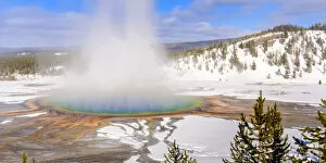 Steam rising from Grand Prismatic thermal pool in snow covered landscape. Midway Geyser Basin