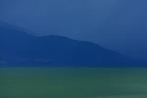 Macedonia Prints: Storm clouds over Pelister making the lake water look green and milky, from Stenje village