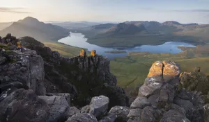 Summer sunrise looking towards Loch Lurgainn from Stac Pollaidh, Iverpolly, Highlands, Scotland. August, 2019 Summer sunrise looking towards Loch Lurgainn from Stac Pollaidh, Iverpolly, Highlands, Scotland. August, 2019
