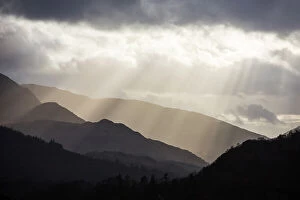 Images Dated 28th April 2020: Sun rays shining through clouds onto Loughrigg Fell and hills of the Lake District National Park