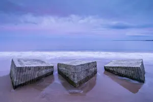 Northumberland Prints: Tank blocks from World War 2, along the shoreline on beach at sunset