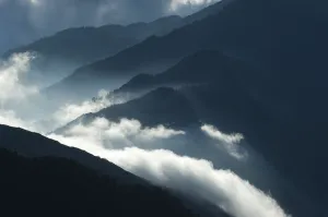 Clouds Prints: Upcoming clouds over forest covered mountains