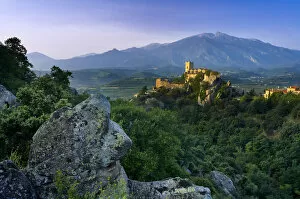 Ancient Gallery: The village of Eus perched on a hilltop with sunlight with the Pic de Canigou beyond