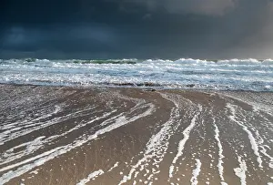 Wave Prints: Waves flowing up the beach and ebbing diagonally causing sediment transport along the beach