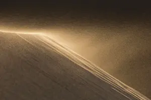 Golden Prints: Wind blowing the sand off a dune in the Sahara desert