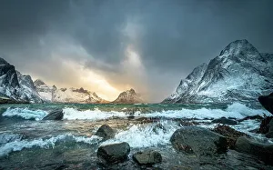 Blue Water Prints: Winter storm clouds gathering along rocky shore surrounded by snow-covered mountains