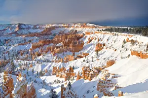 Dramatic Prints: A winter sunrise over snow covered red standstone hoodoos viewed from Sunset Point