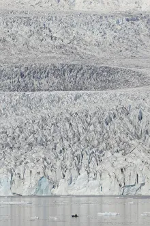Zodiac carrying visitors navigating among ice floes at foot of Fjallsarlon Glacier, Iceland. July
